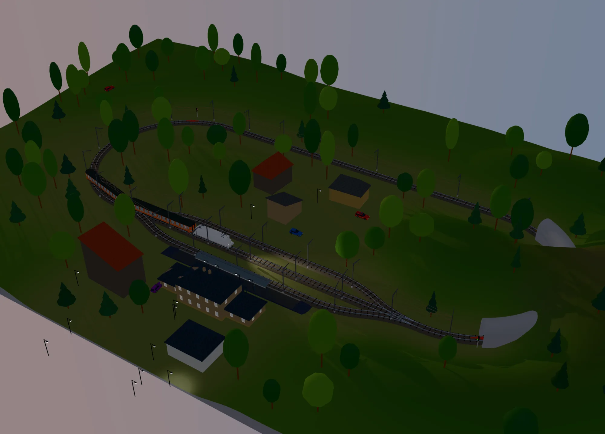 An H0 layout with a three-track station at dusk