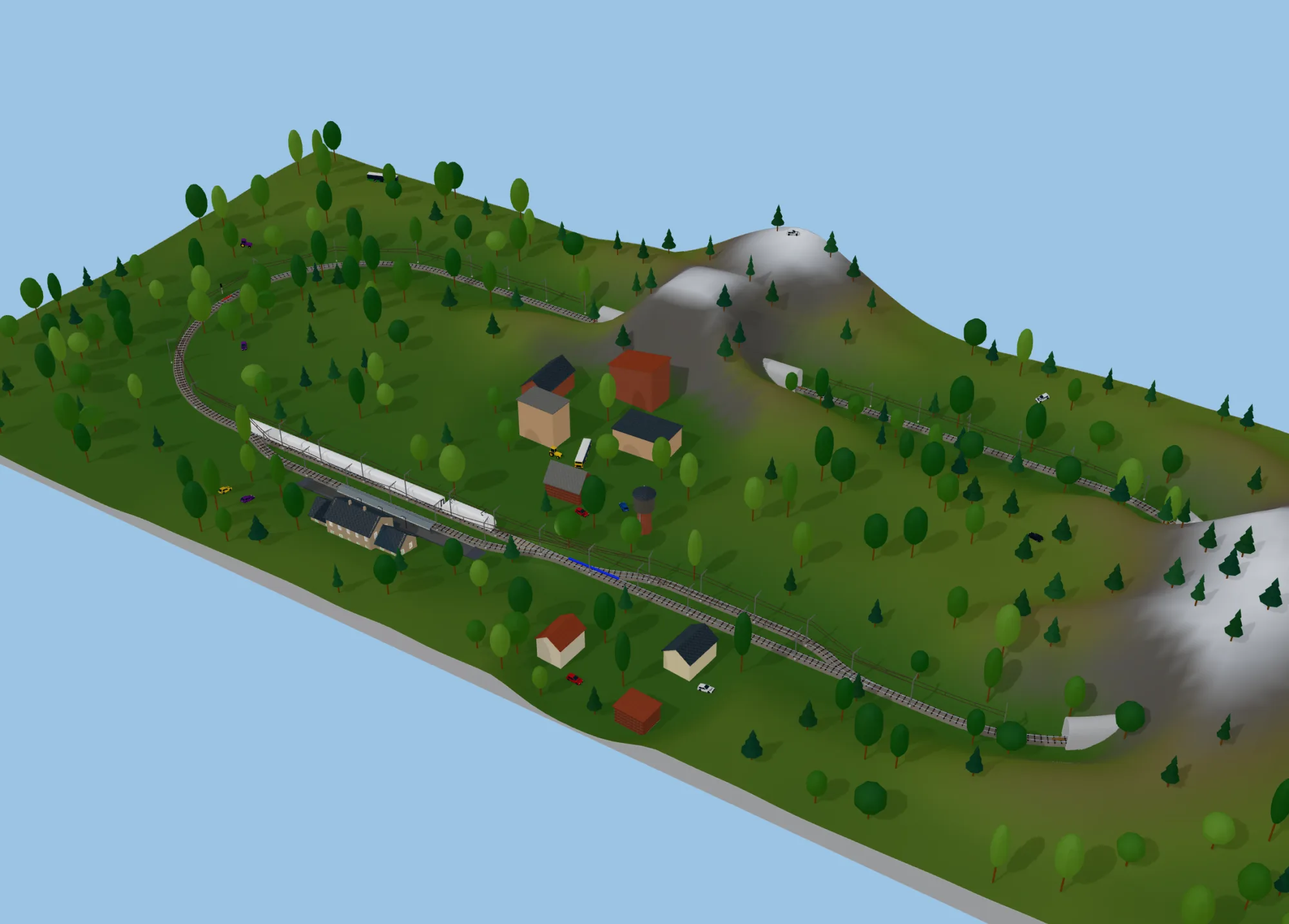 A large H0 oval with a station in the mountains